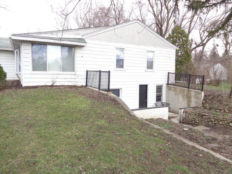 a white house with a hill in front of it