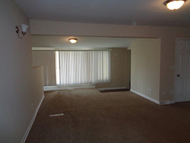 an empty living room with a window and a door