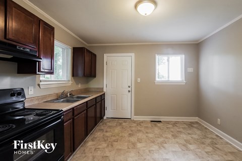 a kitchen with a stove and a sink and a door