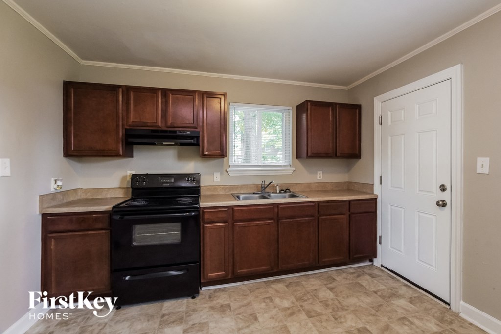 a kitchen with dark wood cabinets and black appliances