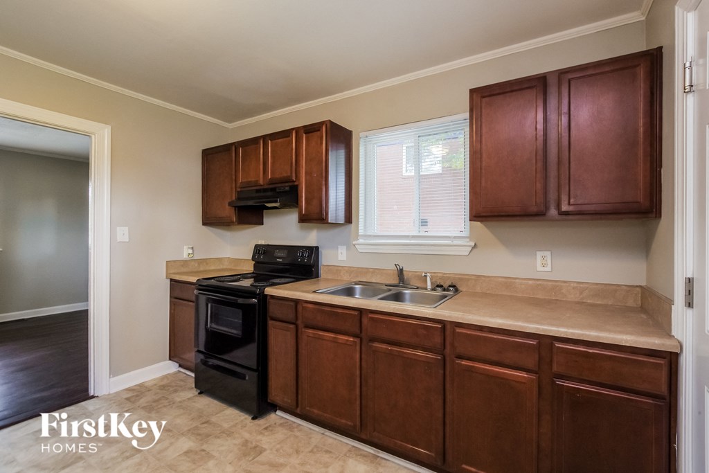 a kitchen with wooden cabinets and black appliances and a sink