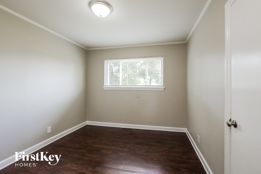 a empty room with wood flooring and a window