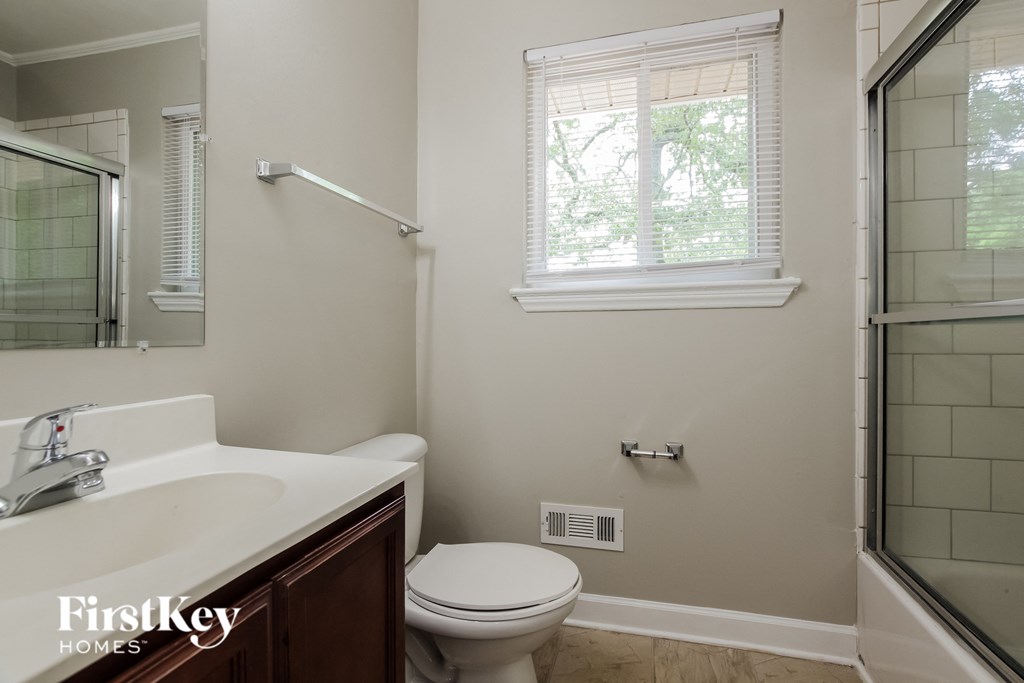 a bathroom with a toilet and a sink and a shower