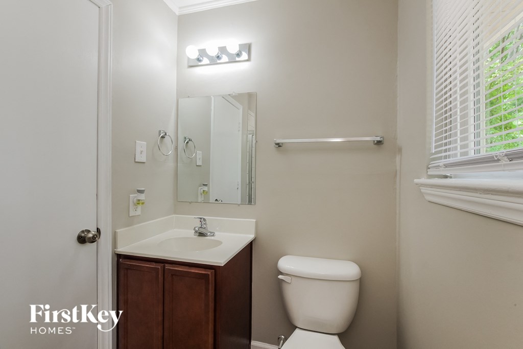a bathroom with a toilet and a sink and a mirror