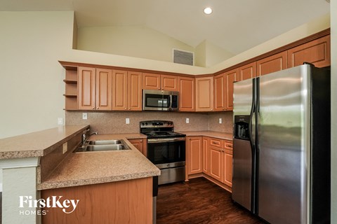 a kitchen with wooden cabinets and stainless steel appliances