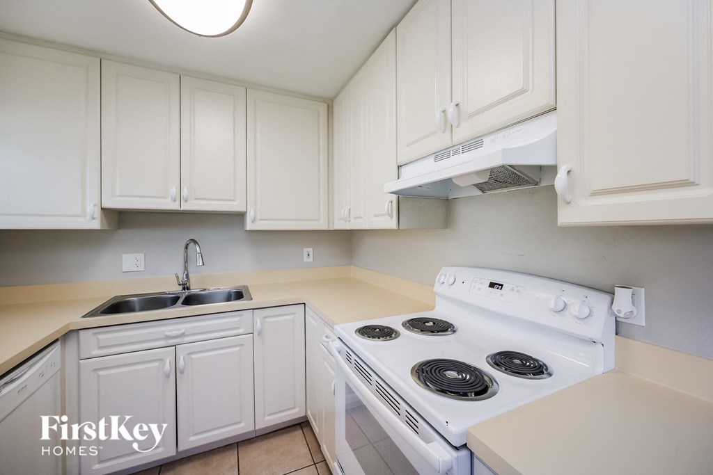 A kitchen with a stove and sink.