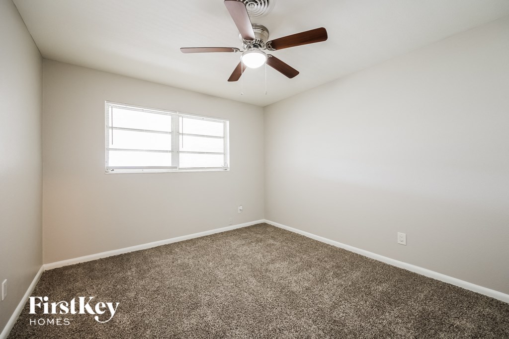 A room with a ceiling fan and a window.
