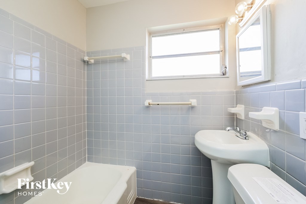 A small bathroom with a toilet, sink, and bathtub.