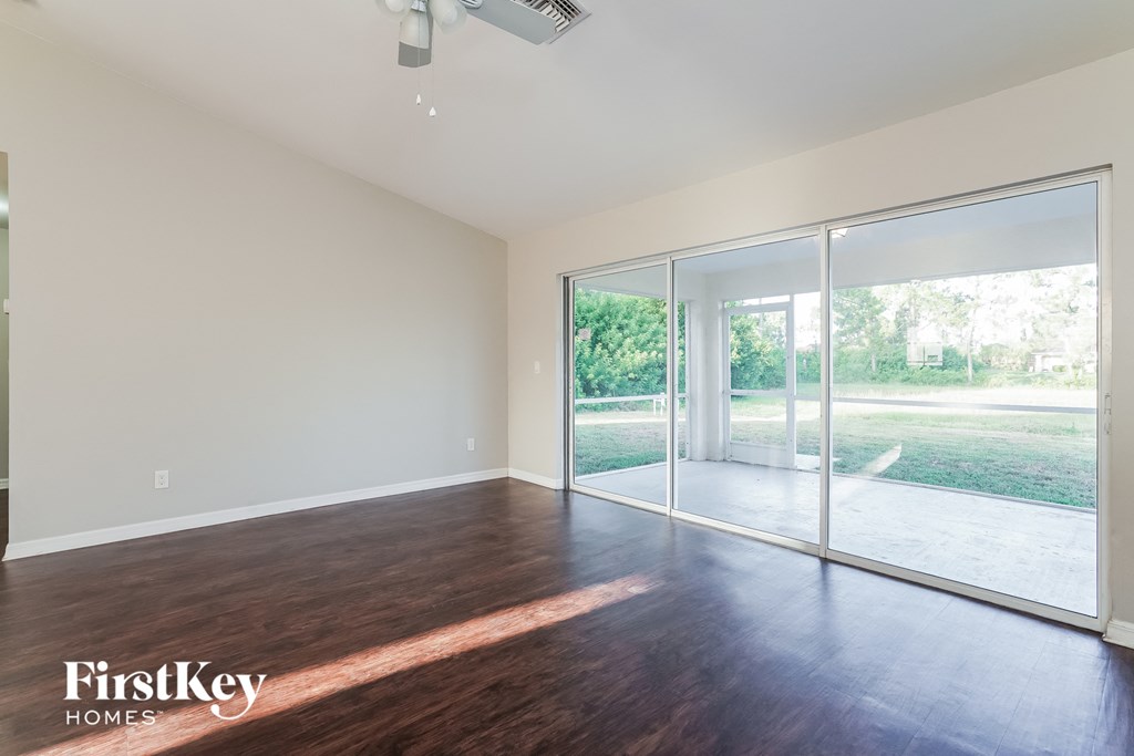 an empty living room with wood floors and sliding glass doors