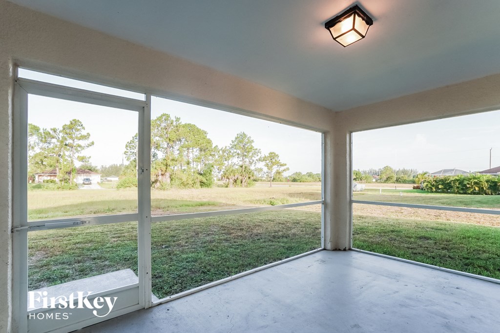 a screened in porch with a view of a field and trees