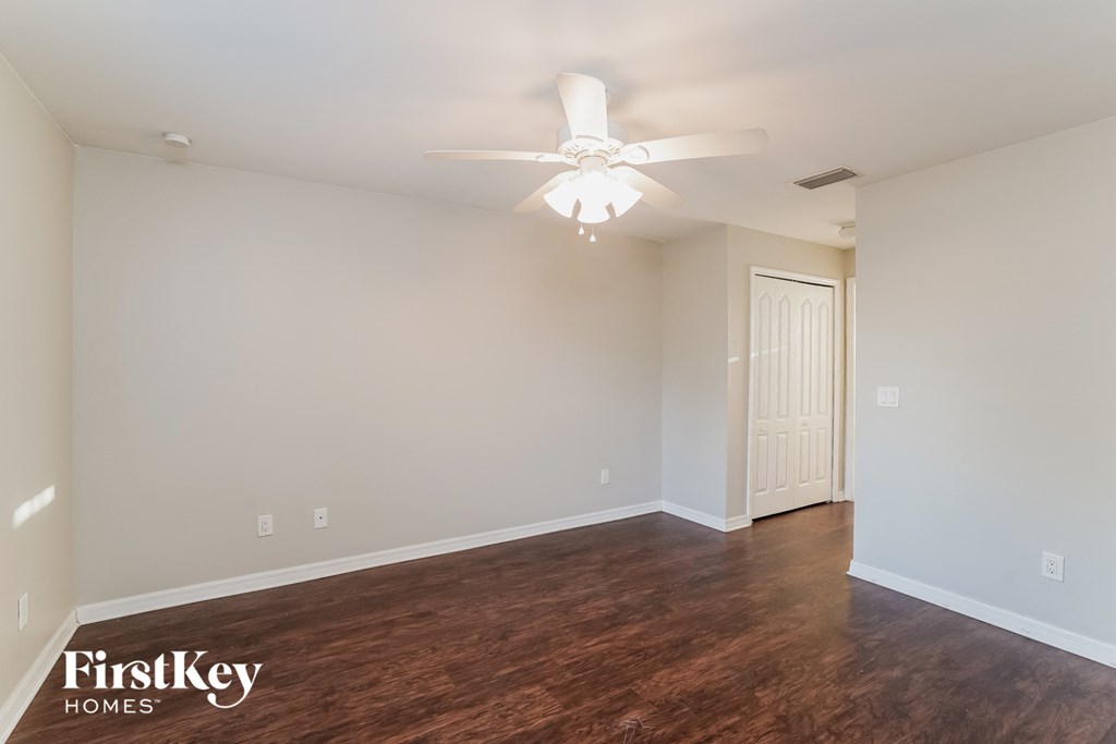 a living room with wood flooring and a ceiling fan