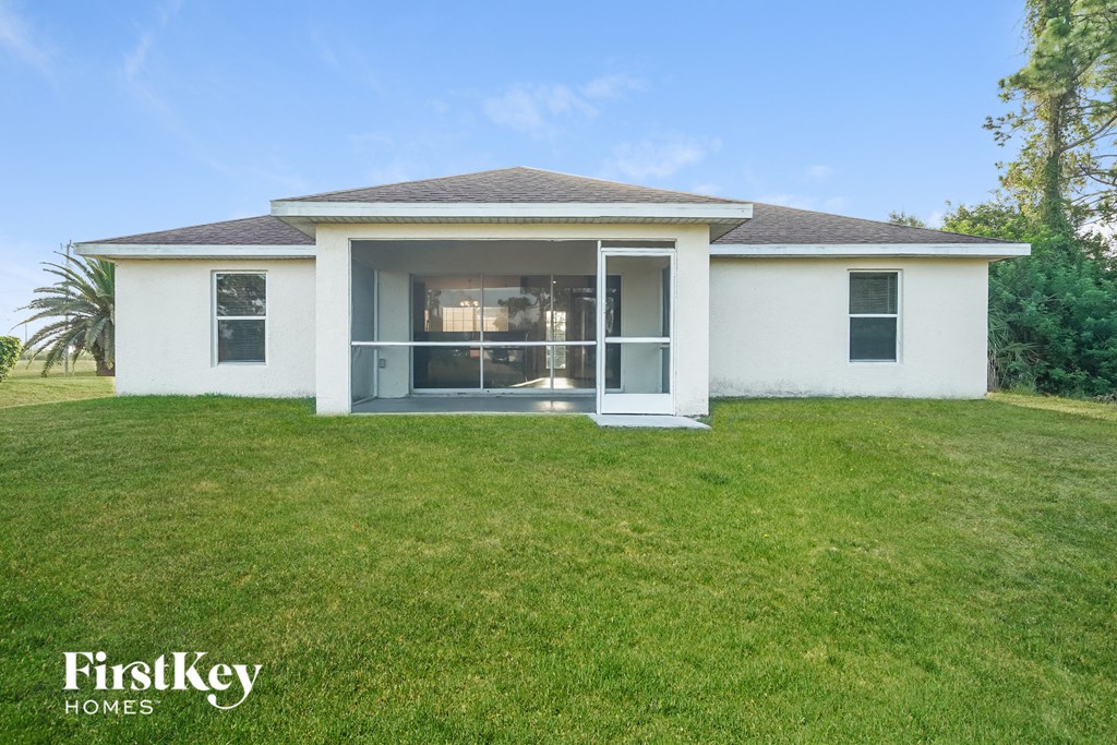 a small white house with a grass yard and a window