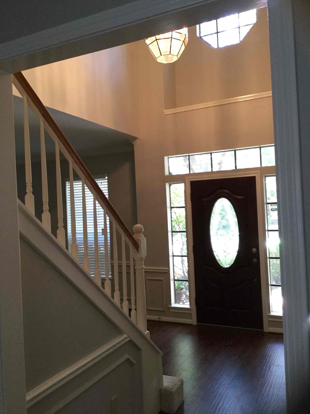 A staircase with a light on the side and a door at the end.