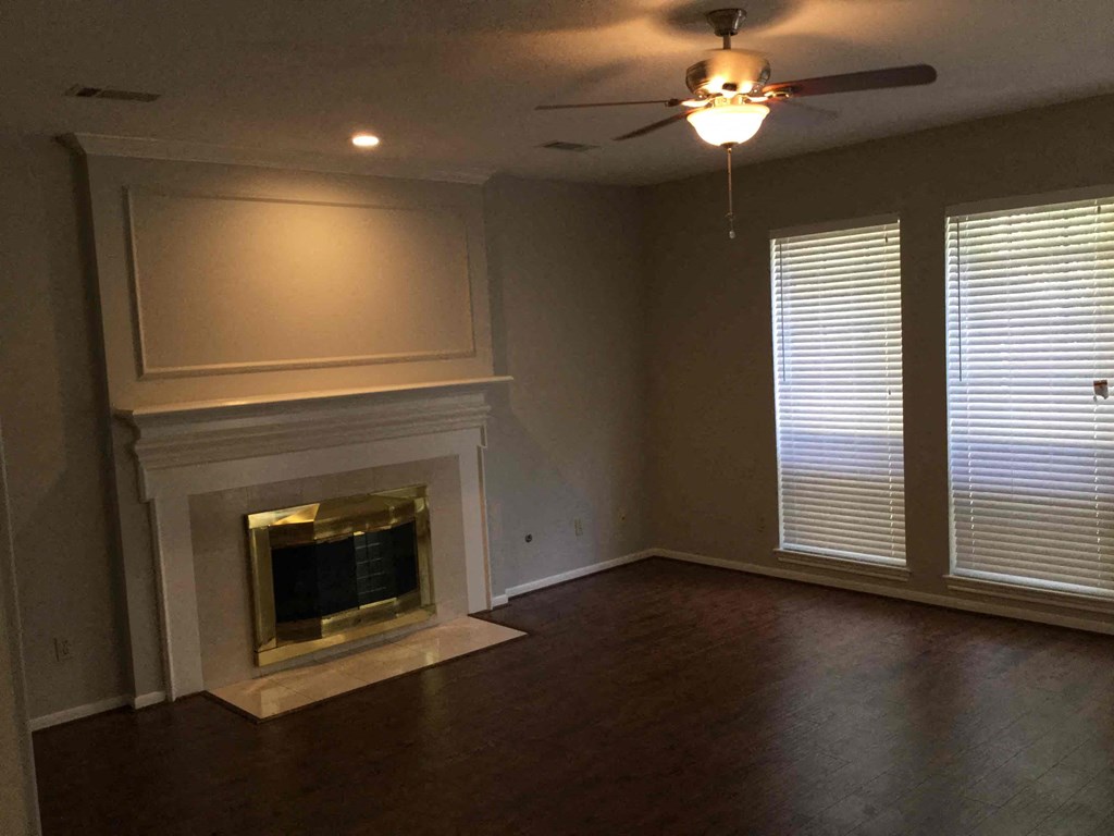 A room with a fireplace and a ceiling fan.