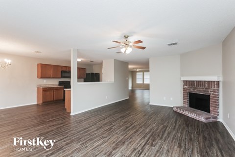 A spacious living room with a fireplace and wooden flooring.