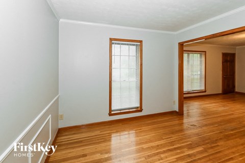 the living room of a house with wood floors and a window