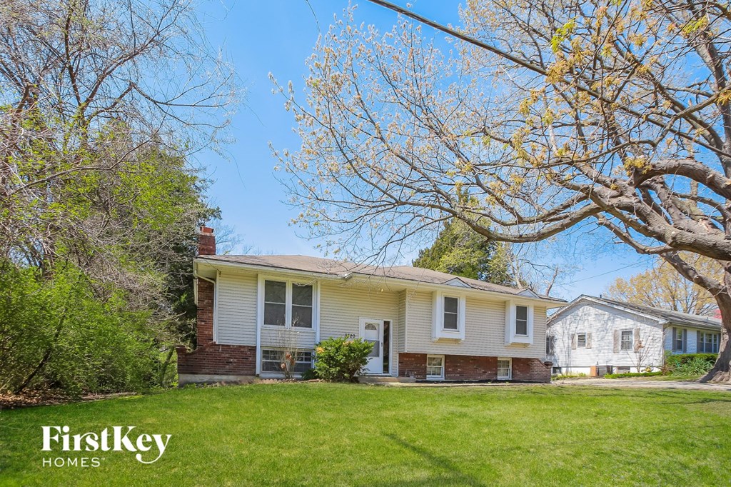 a white house with a yard and a tree