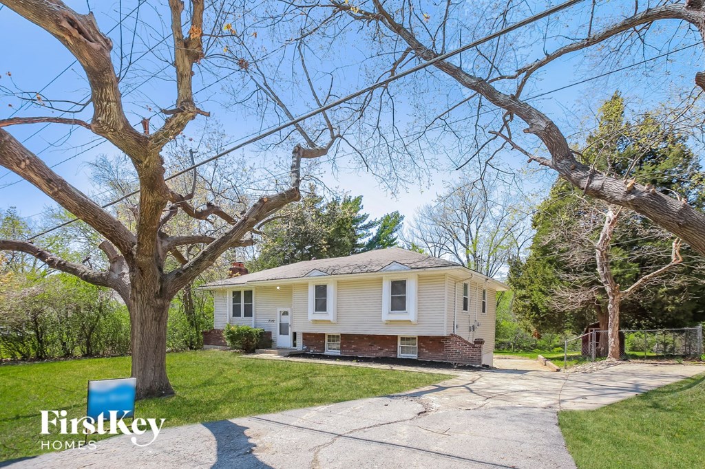 a small yellow house with a tree in front of it
