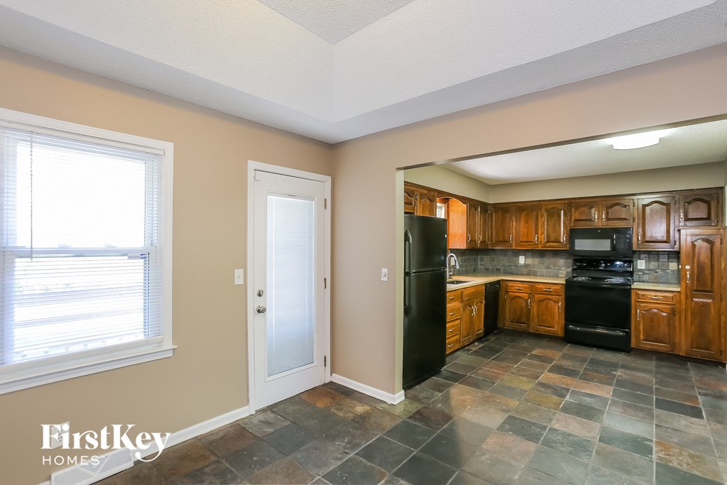 a kitchen with black appliances and wooden cabinets