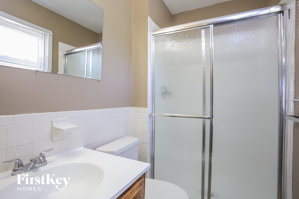 a bathroom with a shower and a sink and a toilet