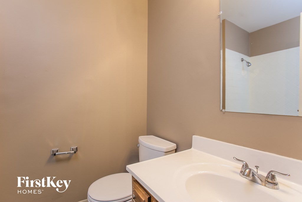 a bathroom with a sink toilet and a mirror