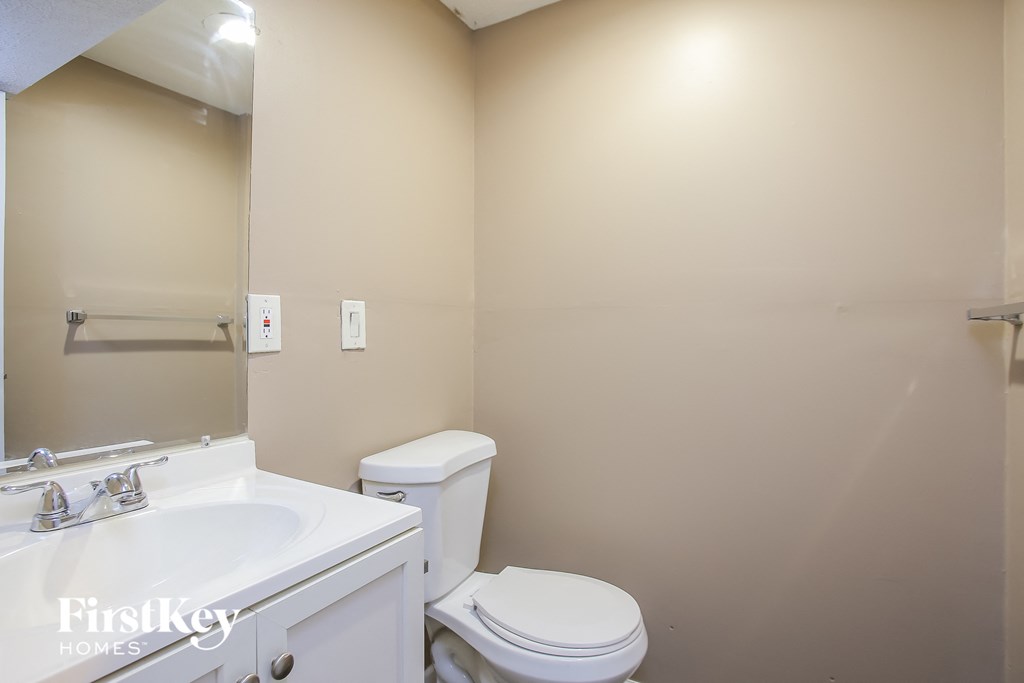 a bathroom with a toilet and a sink and a mirror