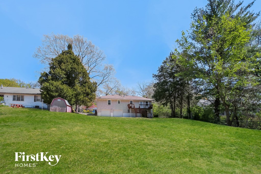 a pink house on a hill with a grassy field