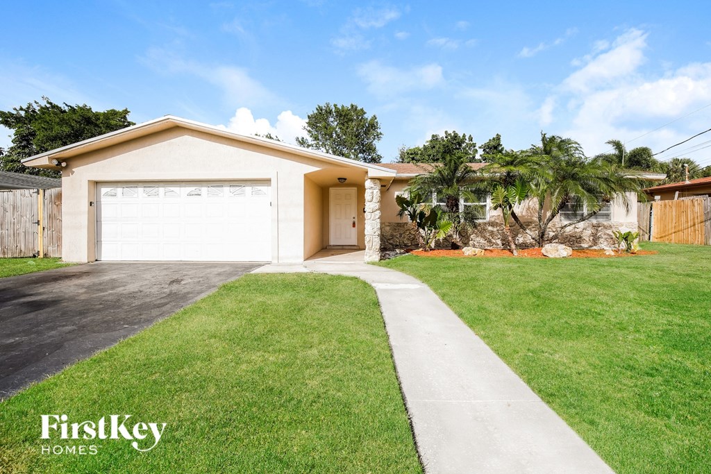 a home with a lawn and a garage door