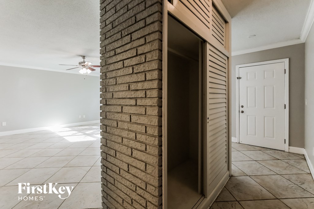 an empty living room with a brick wall and a white door
