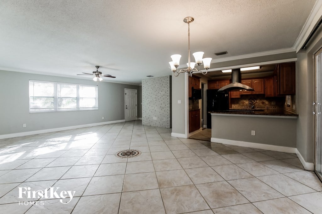 a kitchen and dining room with tile flooring and a ceiling fan