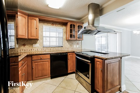 a kitchen with wooden cabinets and a black dishwasher