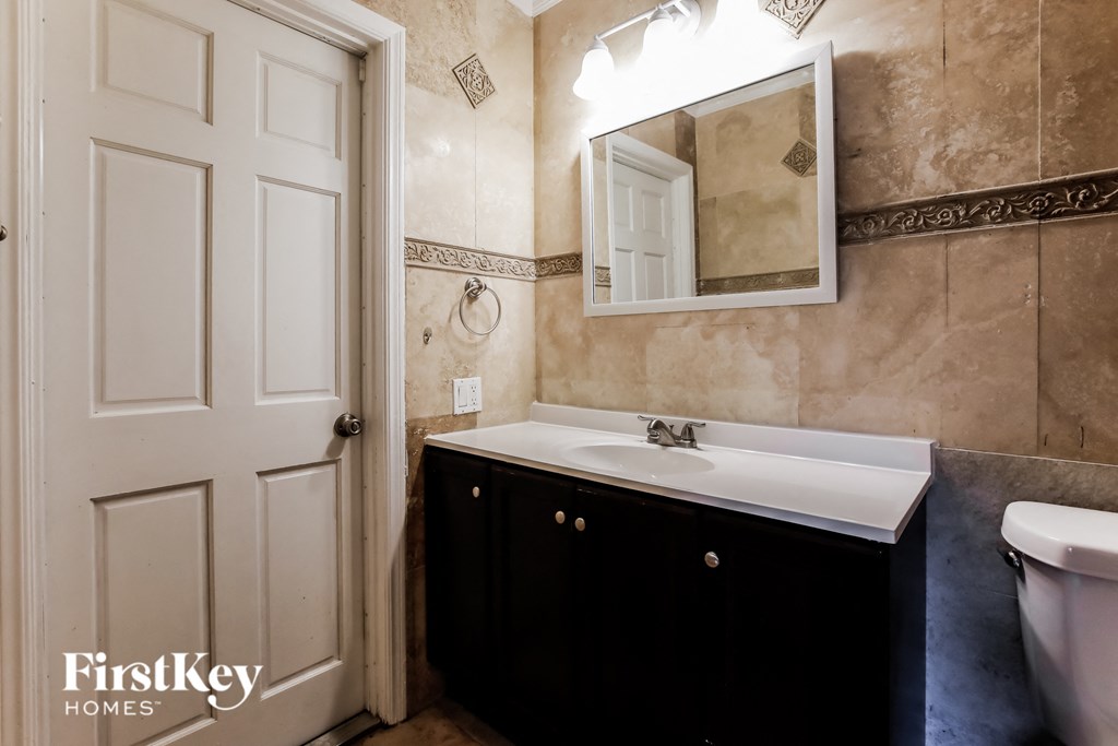 a bathroom with a sink and a mirror and a toilet