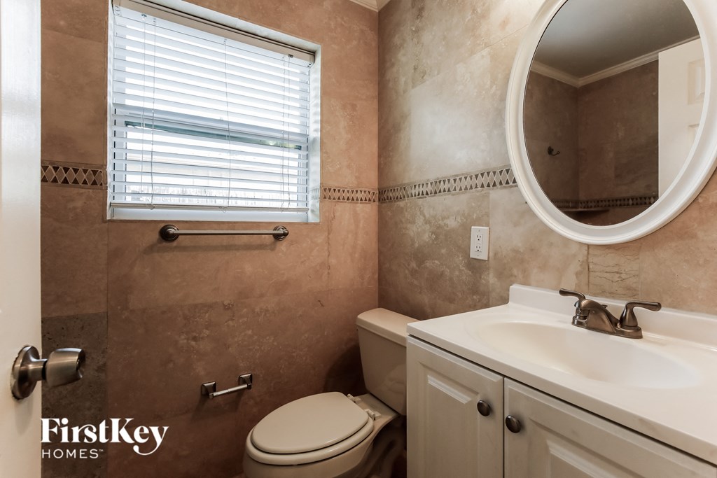 a bathroom with a sink toilet and a mirror