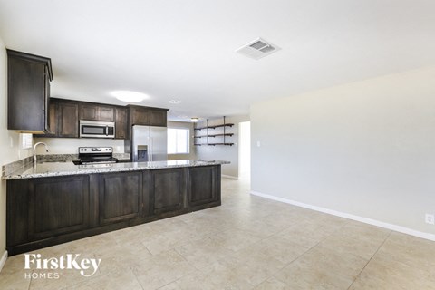 A kitchen with dark wood cabinets and a countertop.