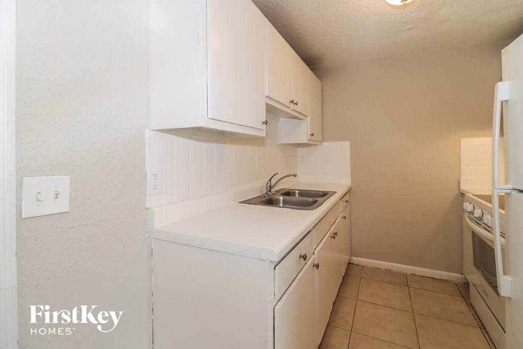 a small kitchen with white cabinets and a sink