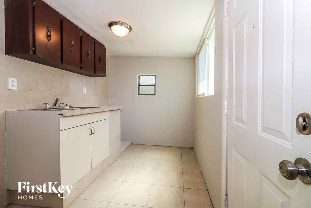 a kitchen with white cabinets and a sink and a window
