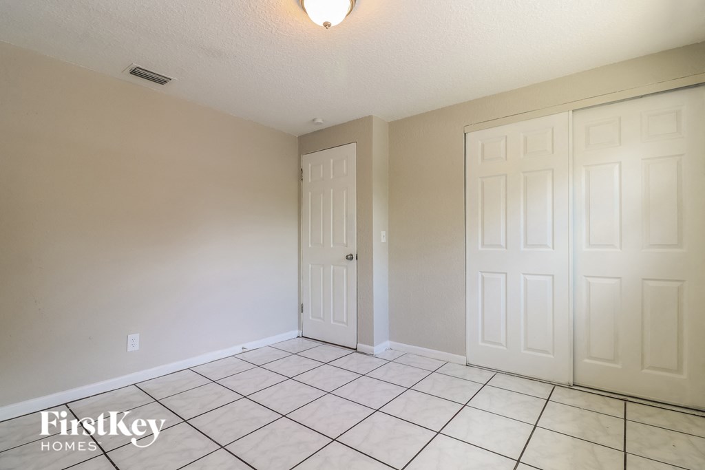 a living room with two closets and a tiled floor