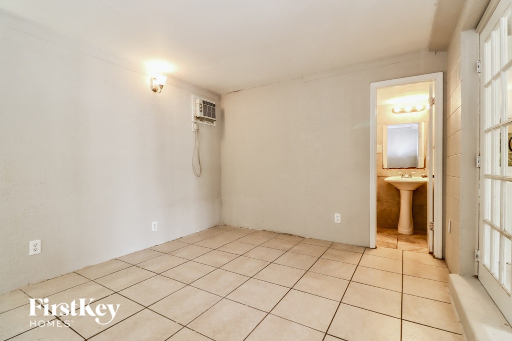 a bathroom with a toilet and a sink and a door to a shower