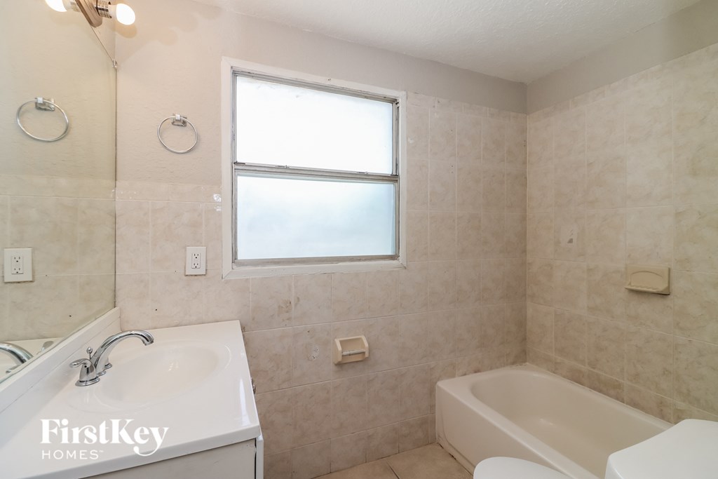 a bathroom with a tub and a sink and a window