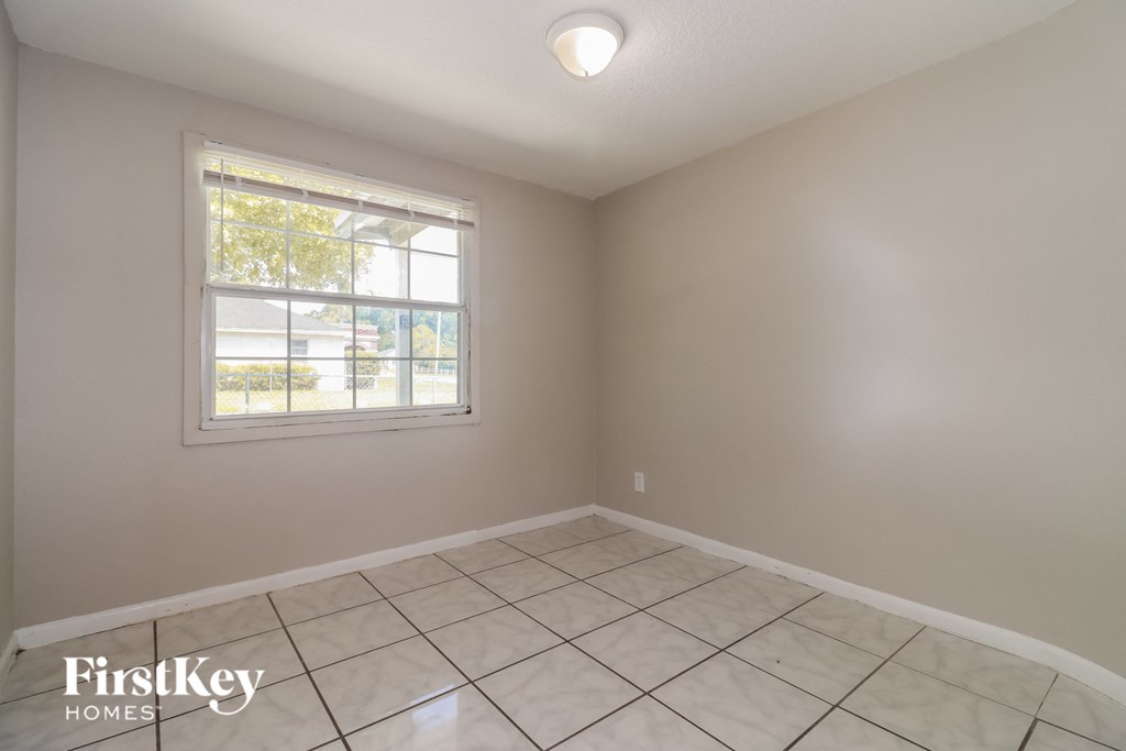 the living room of a home with a tiled floor and a window