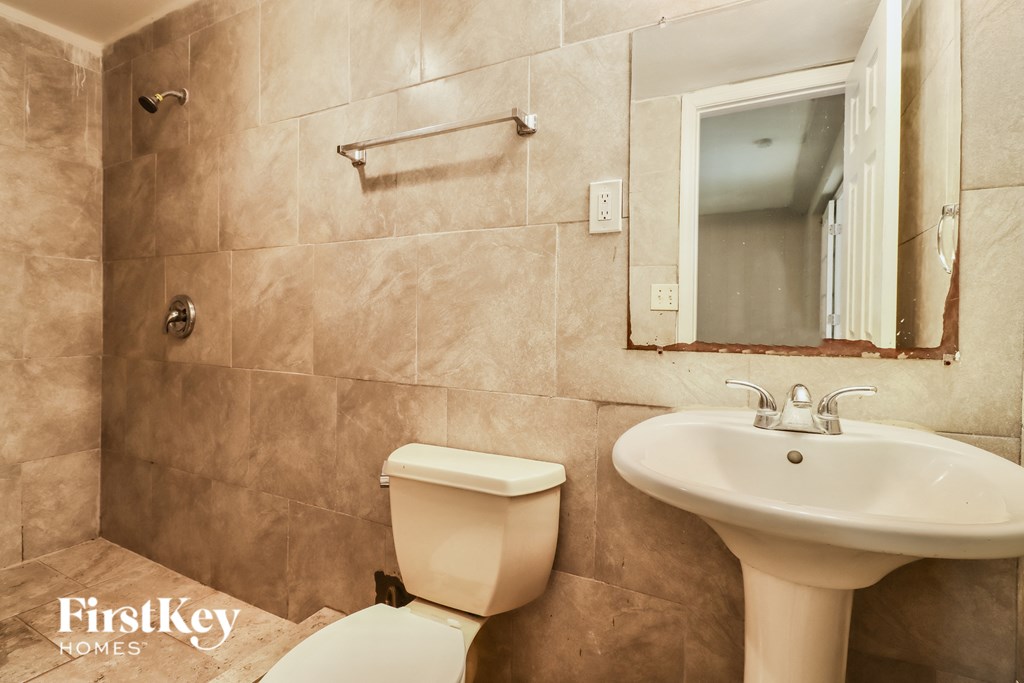 a bathroom with a sink toilet and a mirror