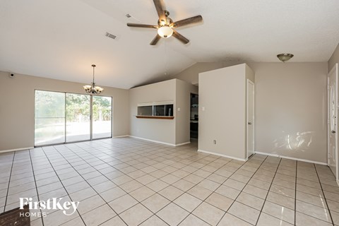A spacious room with a ceiling fan and sliding glass doors.