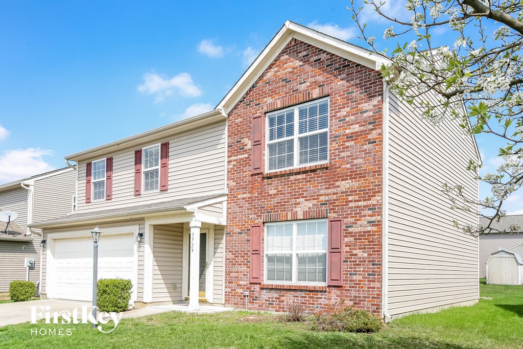 a brick and with red shutters and a blue sky