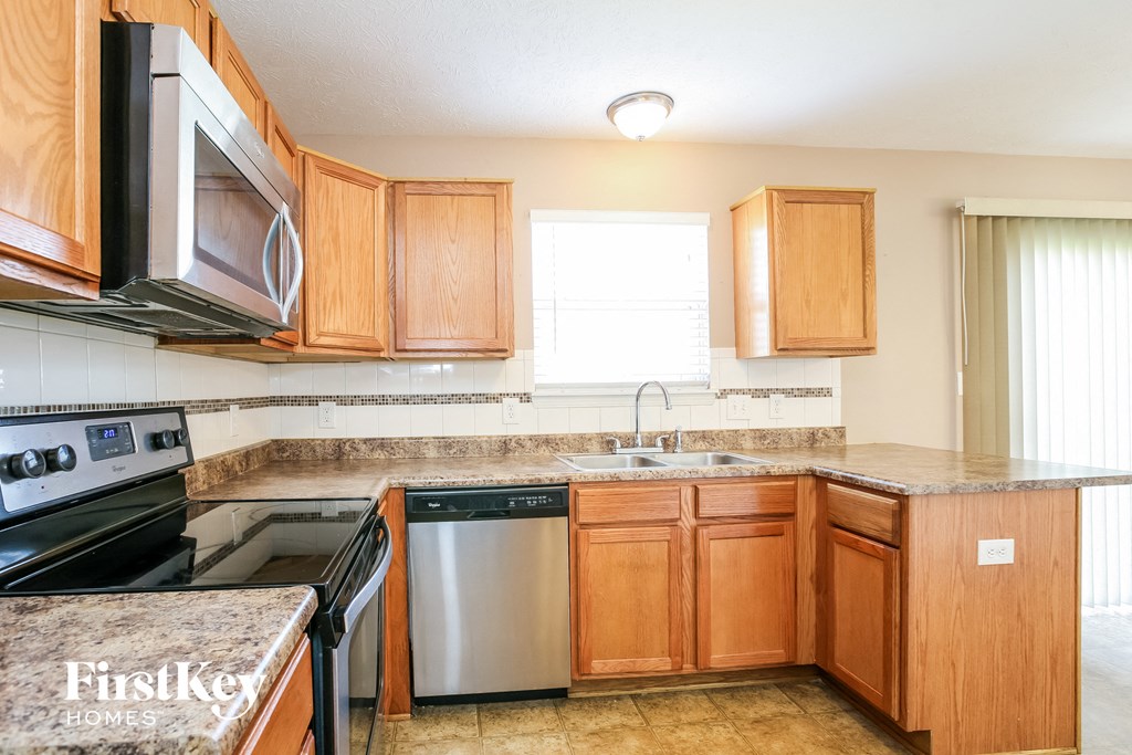 a kitchen with wooden cabinets and stainless steel appliances
