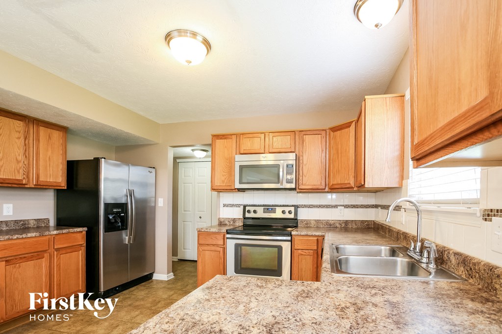 a kitchen with wooden cabinets and stainless steel appliances