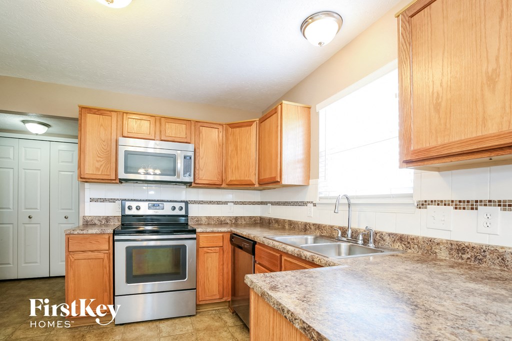 a kitchen with wooden cabinets and stainless steel appliances