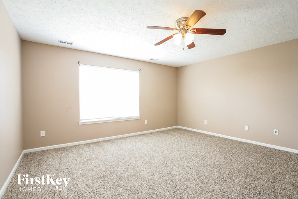 a empty room with a ceiling fan and a window