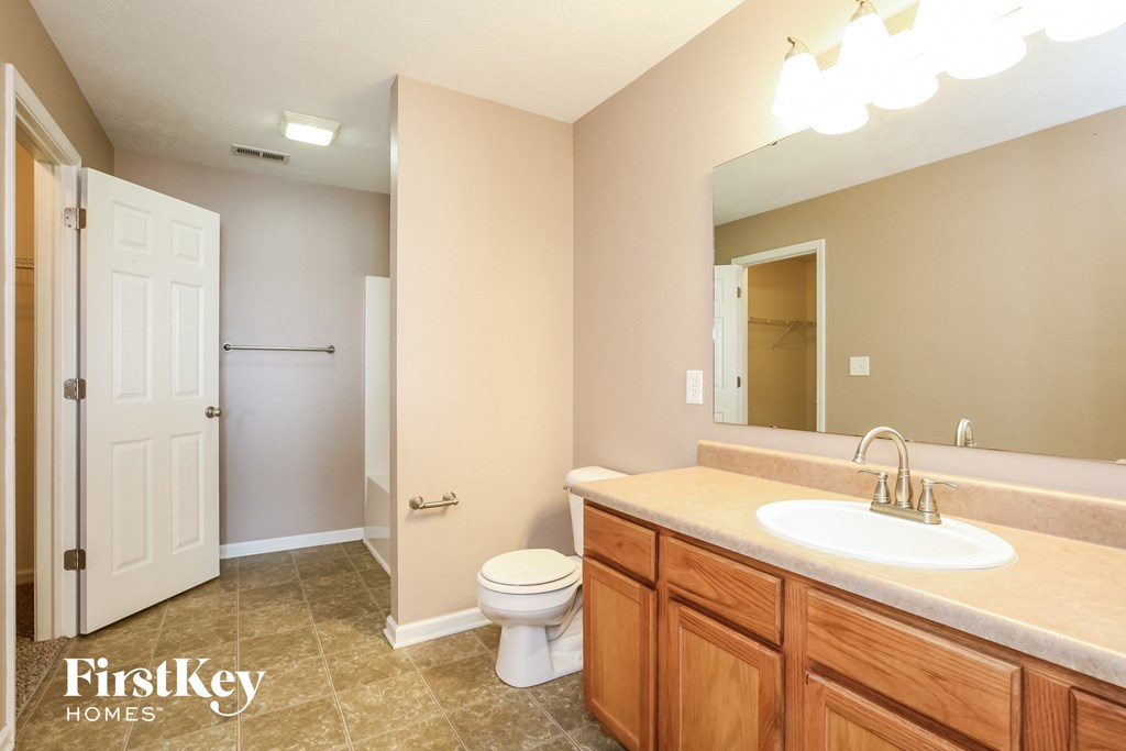 a bathroom with a toilet and a sink and a mirror