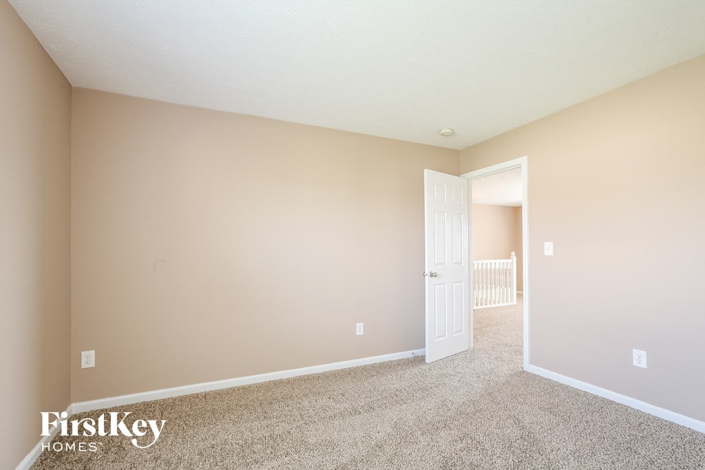 a spacious living room with carpet and a door to a nursery