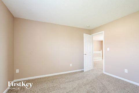 a spacious living room with carpet and a door to a nursery